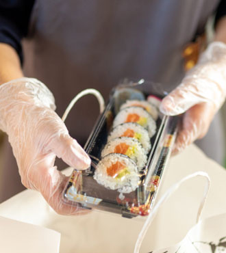 テイクアウトのお寿司を梱包する従業員
